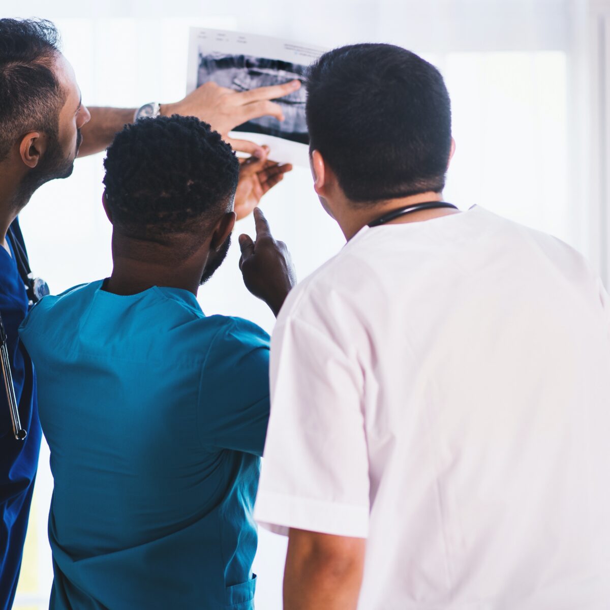 Doctors looking and pointing towards a printed medical scan