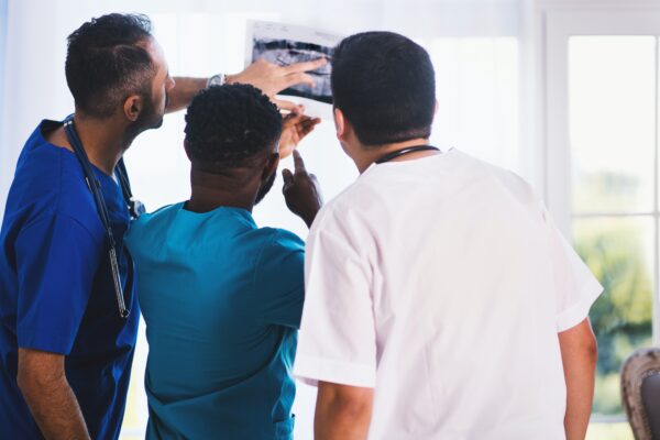 Doctors looking and pointing towards a printed medical scan
