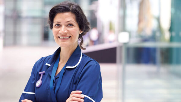 Upper body shot of a healthcare employee smiling toward the camera